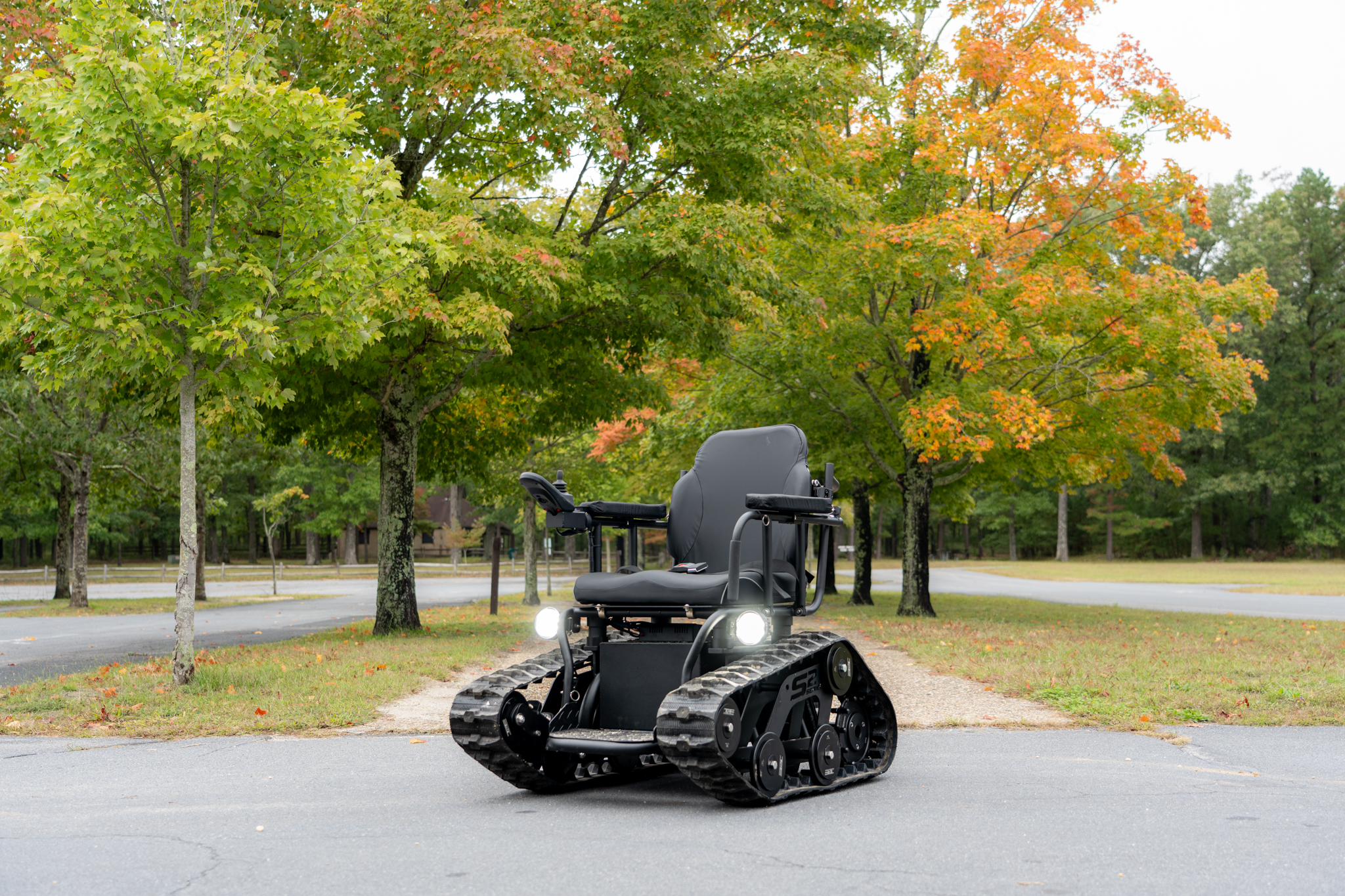 A wheelchair centrally featured among park roads and greenery